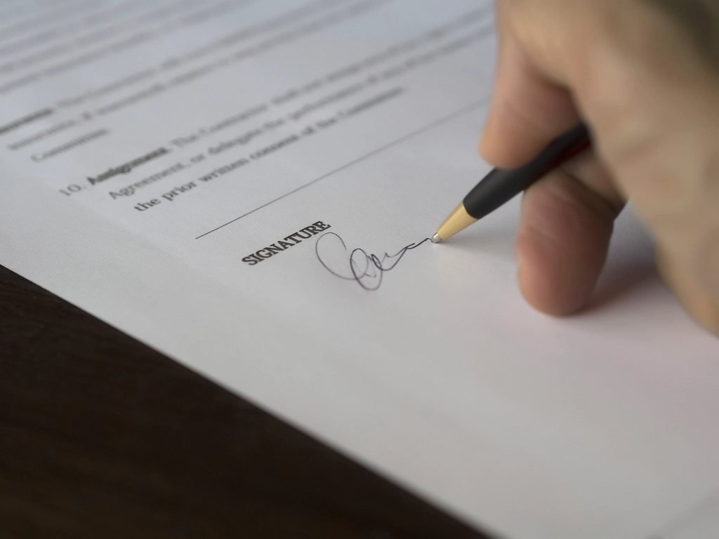 Homeowner signing the signature line of a written construction contract